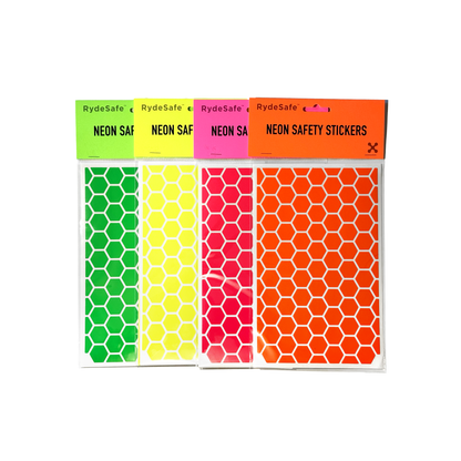 RydeSafe large hexagon bike safety decals in fluorescent pink, yellow, green, and orange, displayed together to showcase the full color range for high visibility and style.